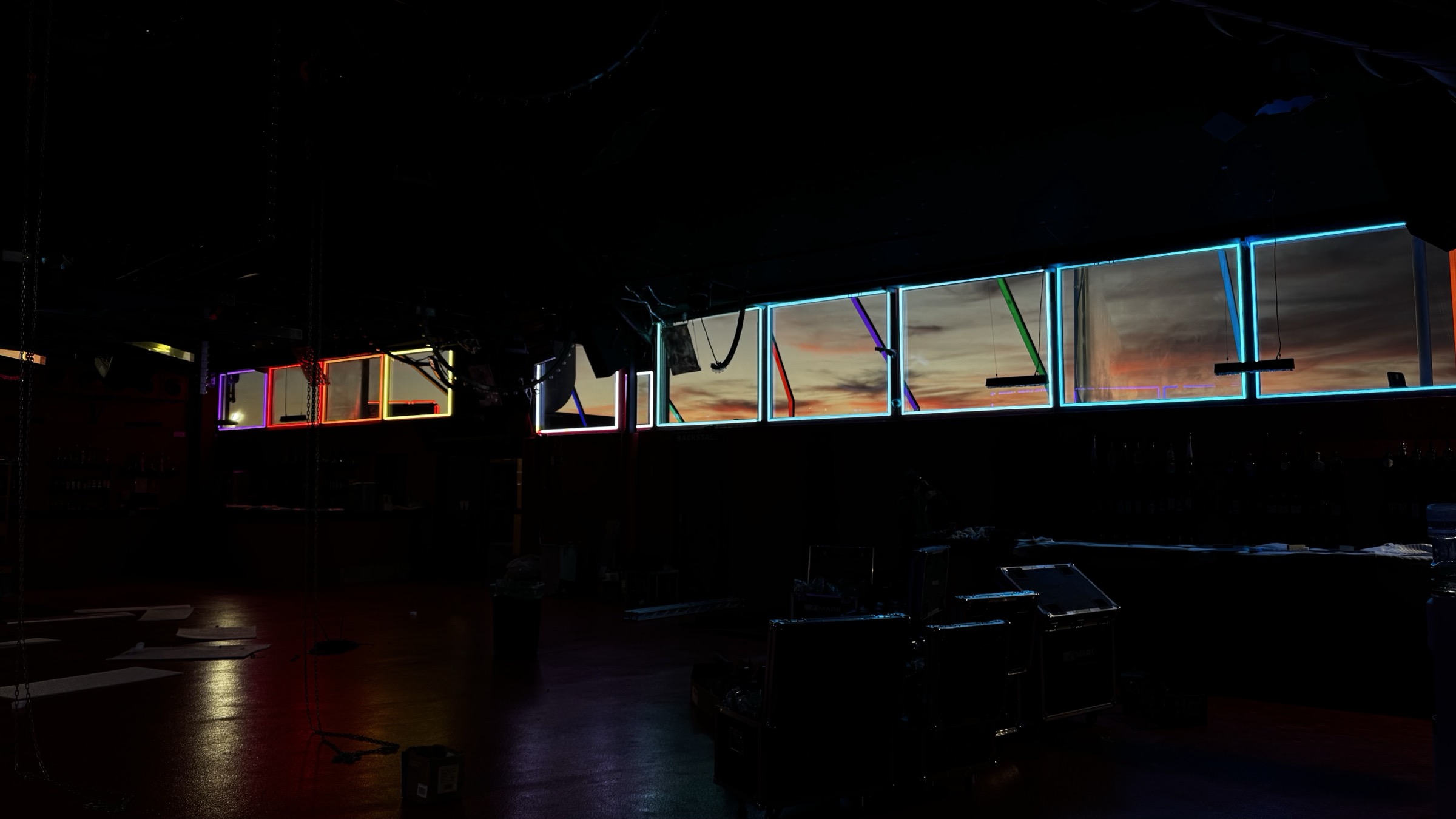Solid Grooves — Music Made Visible — Hilera de cajas de luz retroiluminadas en la pared del club.