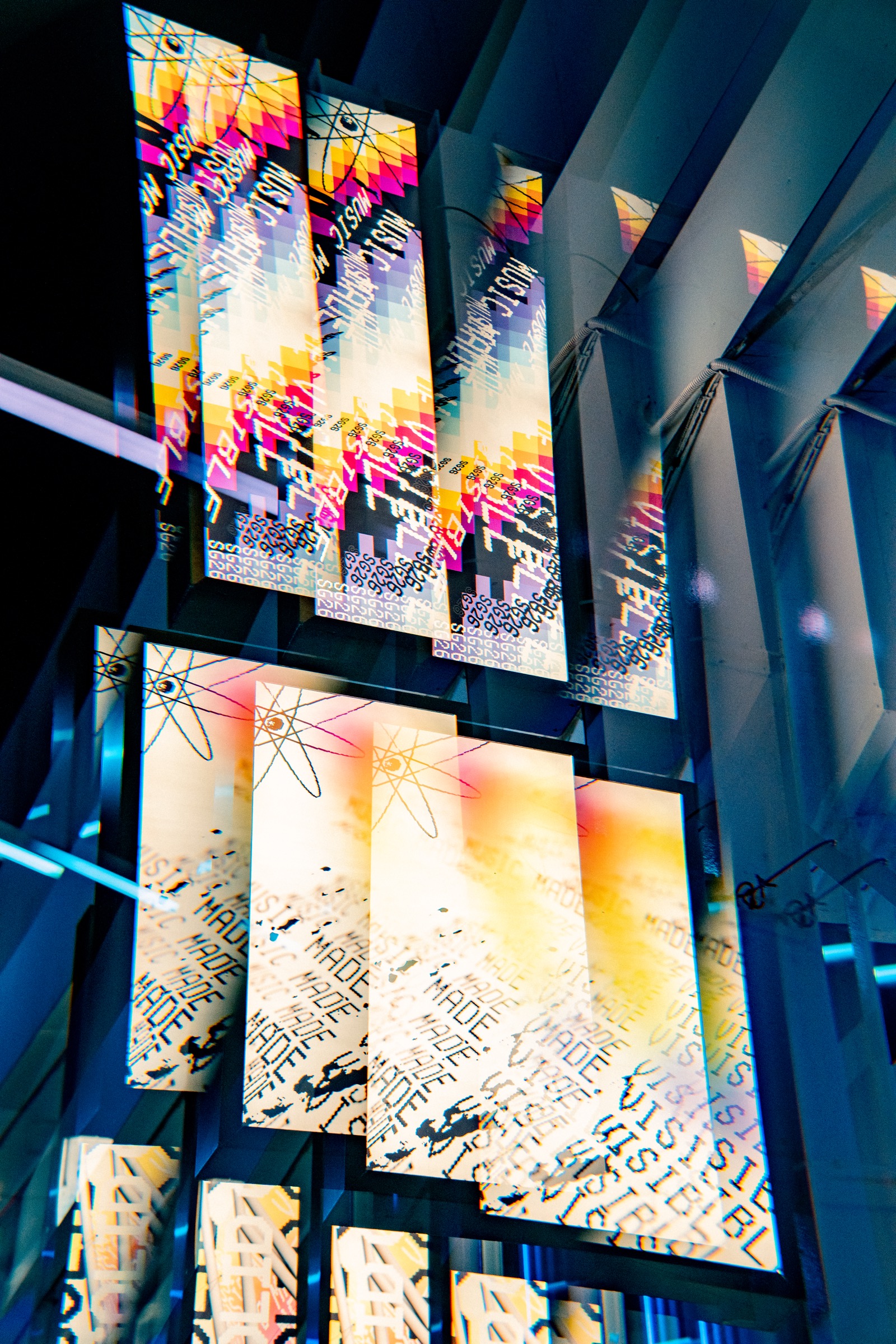Solid Grooves — Music Made Visible — Los banners «Music Made Visible» retroiluminados sobre la pista — el átomo del estudio en tira vertical.