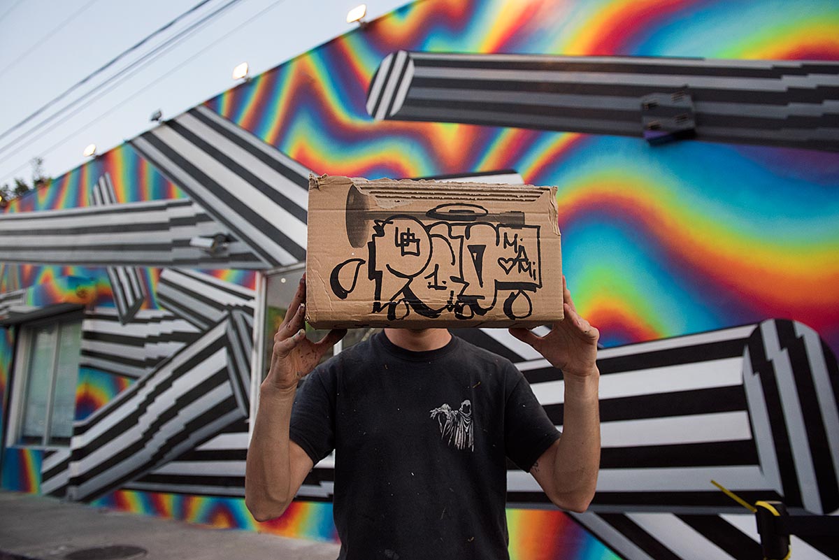 Optichromie for Miami, 2016 — Anonimato a la vieja usanza: cartón delante de la cara.